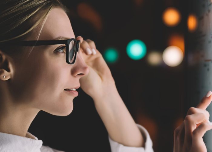 Digital monitor with public transport subway map. Female standing at big display with advanced innovative technology. Young woman touching with finger sensitive screen while selecting surface option