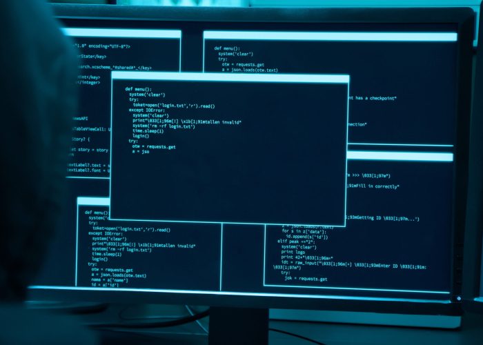 Backview of asian male hacker use computer to commit a crime